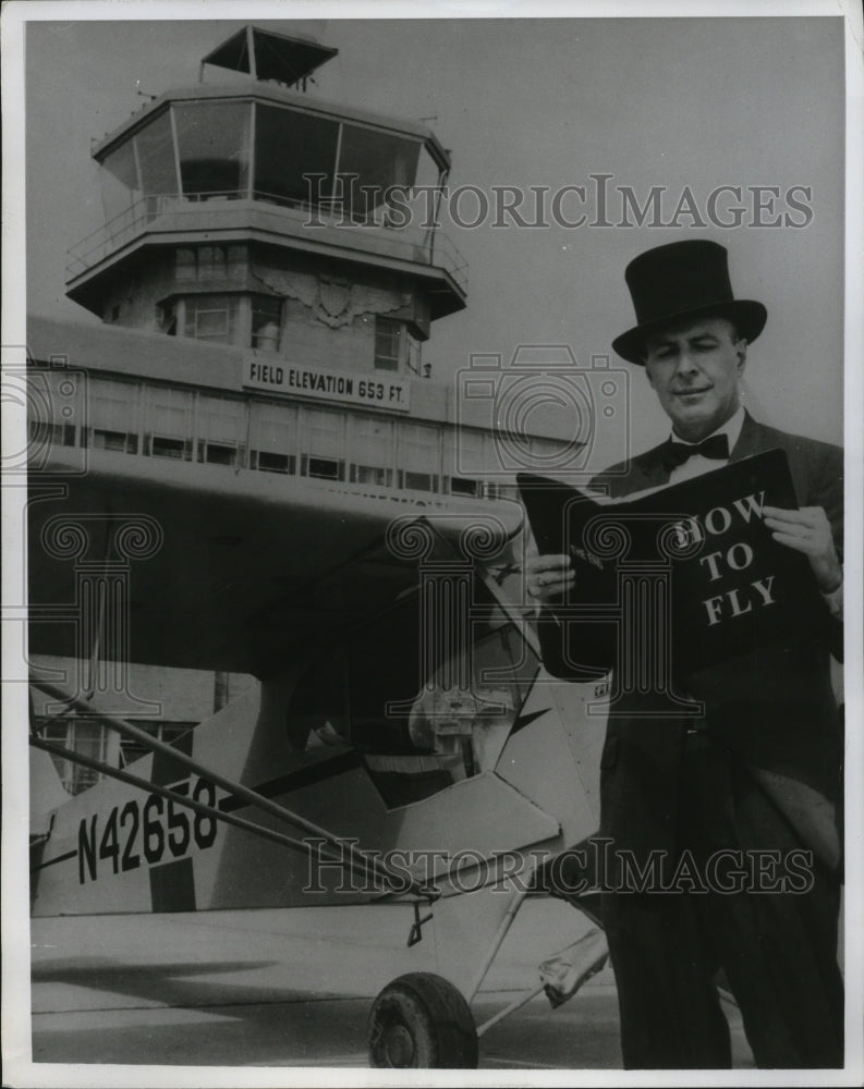 1965 Press Photo Stunt Pilot Captain Dick Schramm Reading &quot;How to Fly&quot;- Historic Images