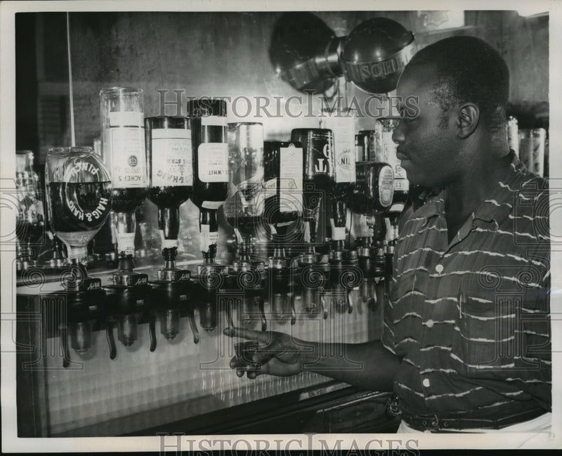 Load image into Gallery viewer, 1957 Press Photo Bartender Allen B. Jones Demonstrating Shot Lever Dispensers
