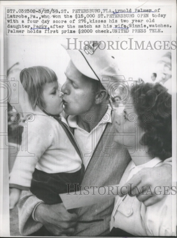 Load image into Gallery viewer, 1958 Press Photo Arnold Palmer kisses his two-year-old daughter, Peggy
