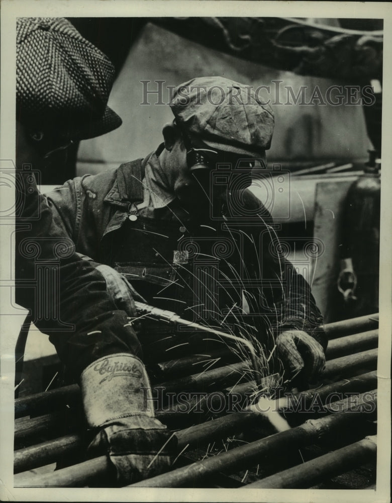 Load image into Gallery viewer, 1940 Press Photo welder soldering pipes together to form one cylinder
