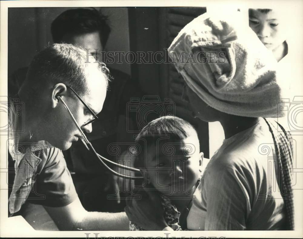 1963 Press Photo First Lieutenant Joseph Burn examines Child in South Vietnam- Historic Images