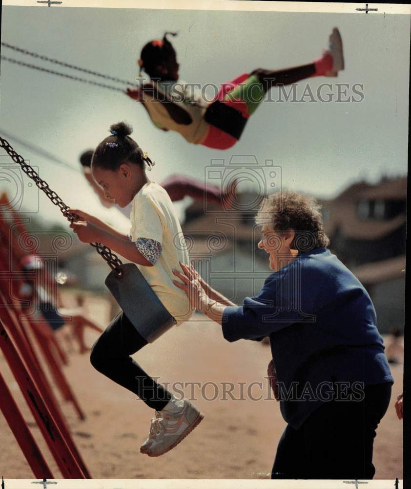 1990 Press Photo Woman pushes child on swing at Lighthouse Park playground- Historic Images