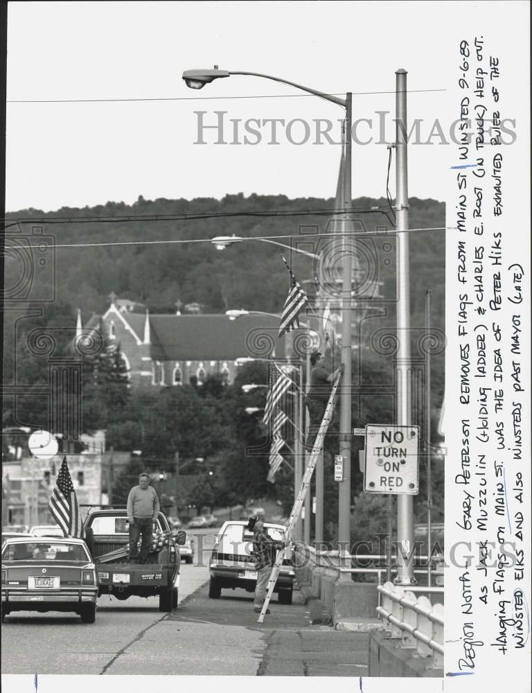 1989 Press Photo Gary Peterson and Jack Muzzulin install Flags in Winsted- Historic Images