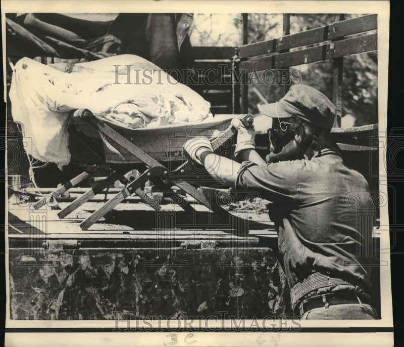 Load image into Gallery viewer, 1969 Press Photo Hurricane Camille - A Seabee loads body of a victim on truck.
