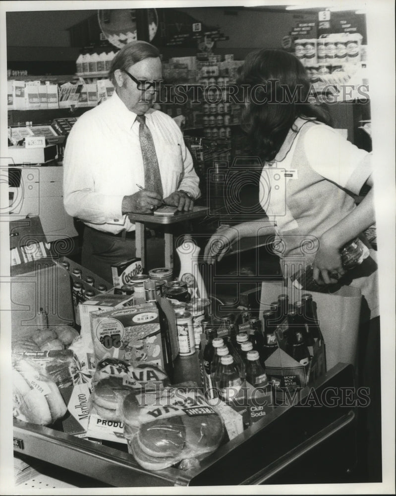 Load image into Gallery viewer, 1977 Press Photo Hurricane Babe- Thomas L. Hoberg -stocking up for storm.
