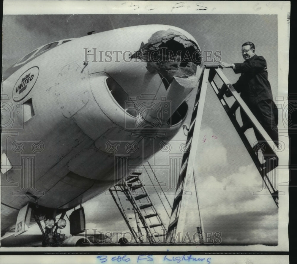 1969 Press Photo Clarence Rees inspects United Air Lines plane hit by lightning.- Historic Images