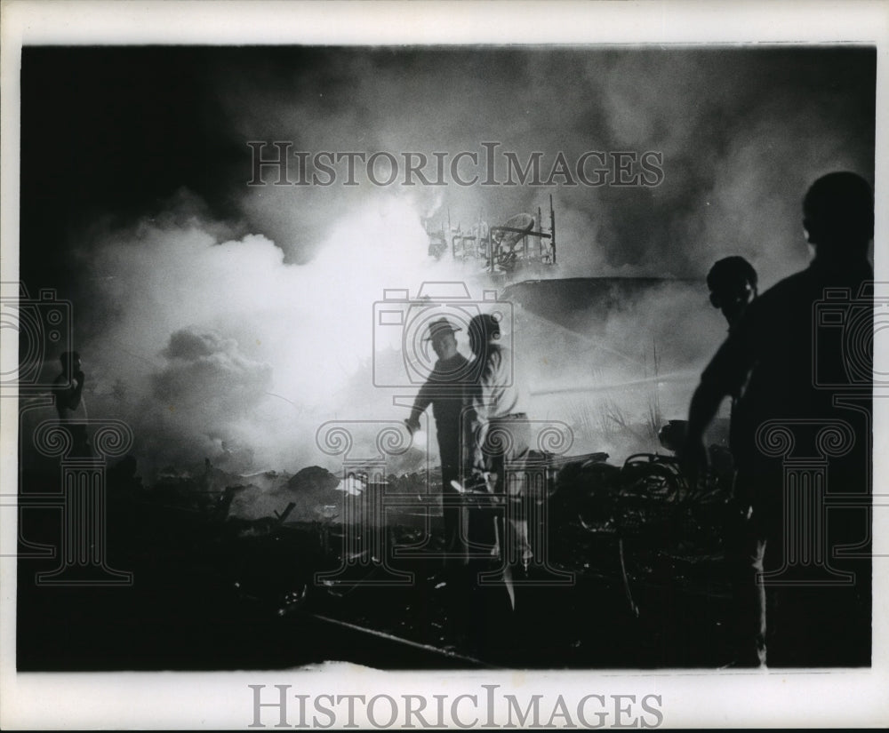 1967 Press Photo Airplane Accidents- Smoke and flames backlight firefighters.- Historic Images