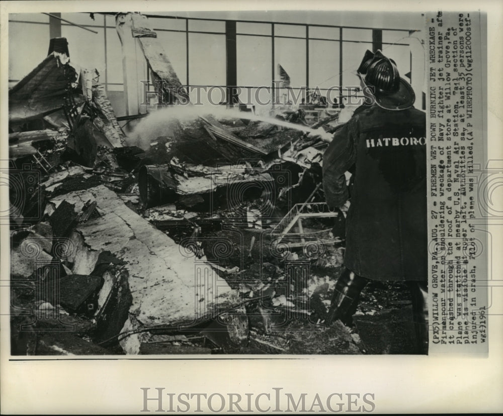 1961 Press Photo Airplane Accidents-Firemen pour water on Navy jet fighter.
