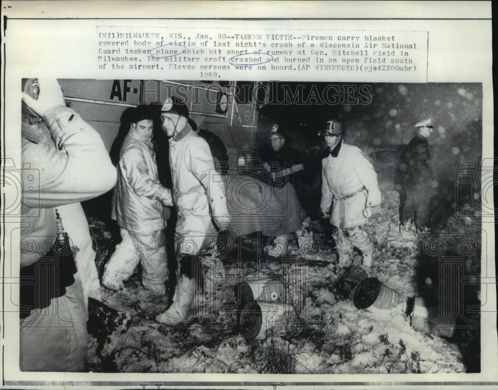 1969 Press Photo Airplane Accidents Firemen carry blanket wrapped body of victim- Historic Images