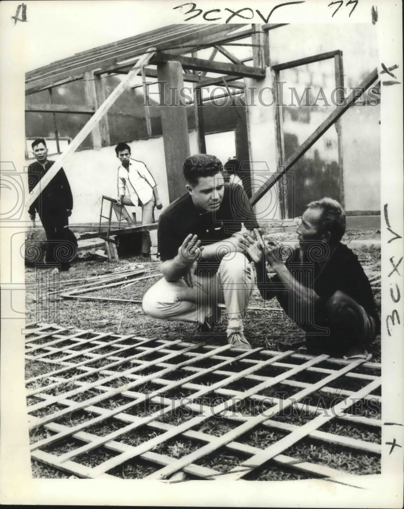 1967 Press Photo Aid official uses sign language to explain building process.- Historic Images