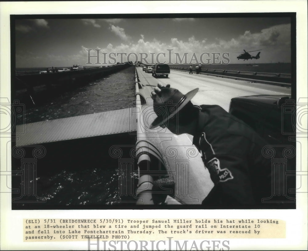 1991 Press Photo Accident-Trooper Samuel Miller holds on  to his hat - Historic Images