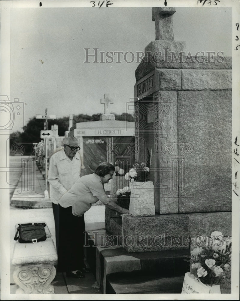 1977 Press Photo Mr. and Mrs. Frank Musso place flowers at grave site tomb