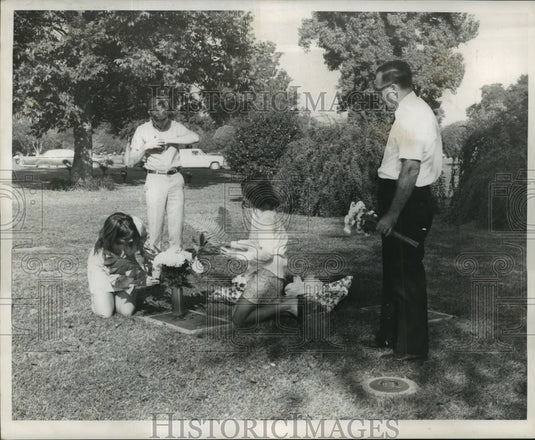 1968 Press Photo All Saints Day - A family places flowers on grave site.- Historic Images