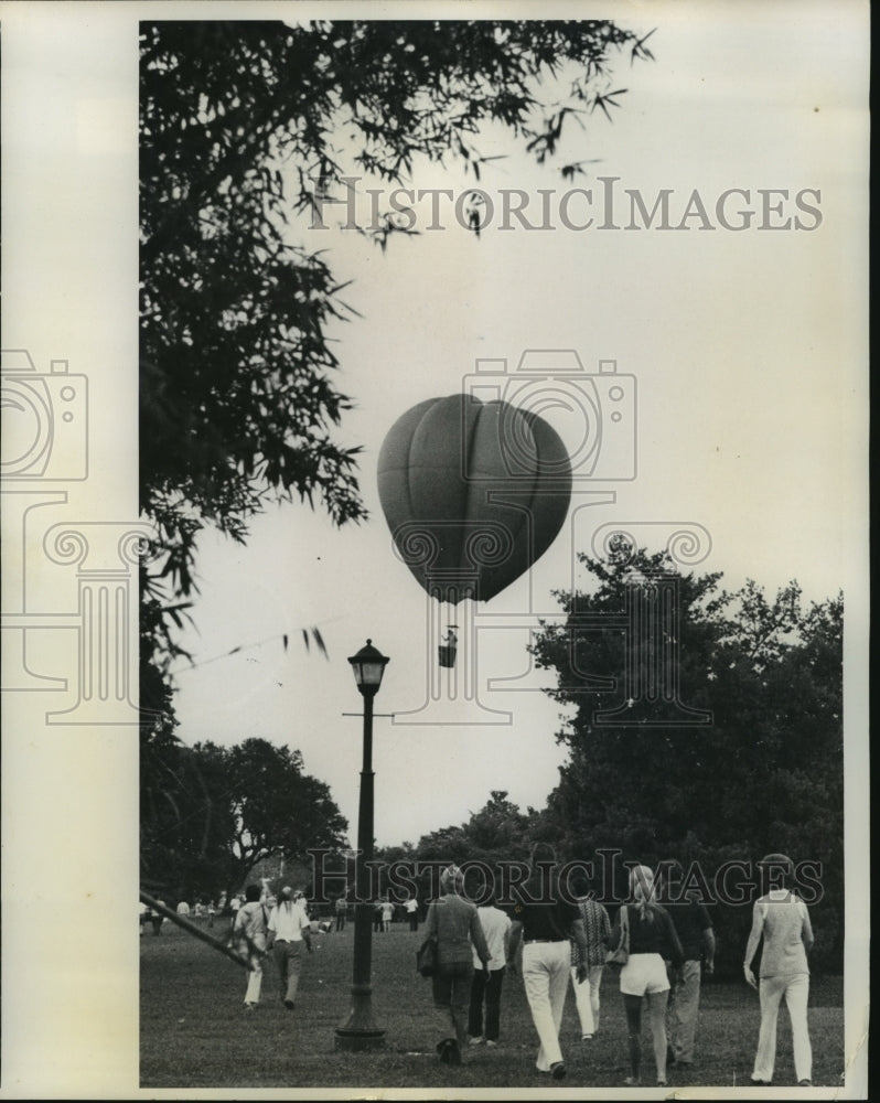 1974 Press Photo Crowds Watch Hot Air Balloon Fly Overhead- Historic Images