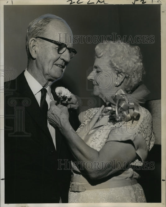 1963 Press Photo Mrs. H. Pat Crane Sr. pins Carnation on husband's coat for 50th- Historic Images