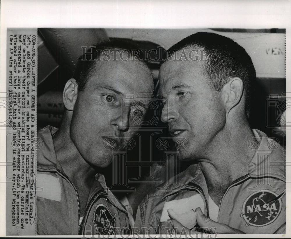 1965 Press Photo Astronauts Conrad and Cooper eat cake aboard Lake Champlain- Historic Images