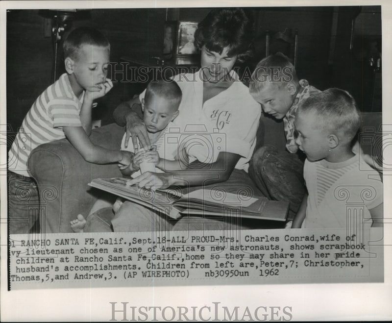 Load image into Gallery viewer, 1962 Press Photo Astronaut Charles Conrad's family looking at his scrapbook
