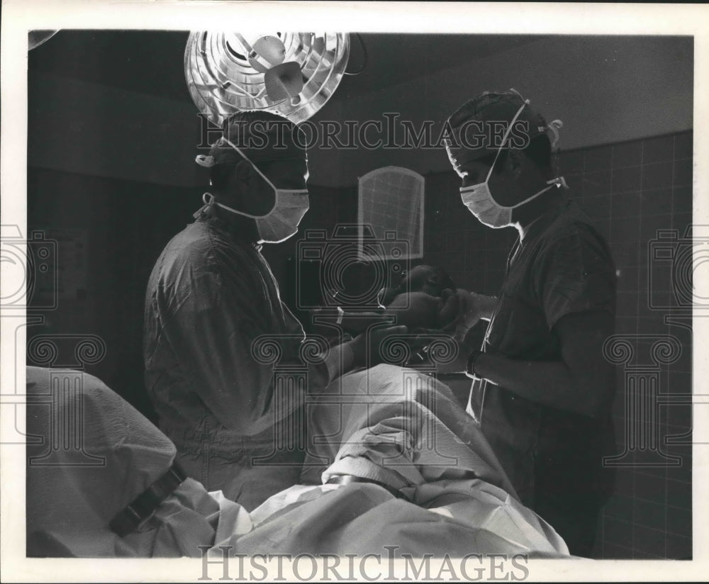  Press Photo Doctors hold newborn baby- Historic Images