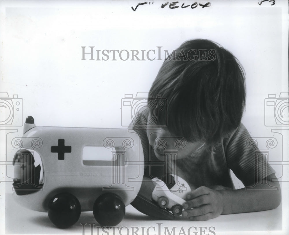  Press Photo A youngster plays with his ambulance, a Christmas gift- Historic Images