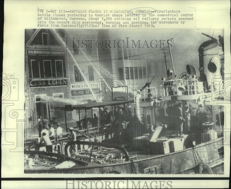 Load image into Gallery viewer, 1969 Press Photo Firemen fight blaze in tourist shops in Willemstad, Curacao

