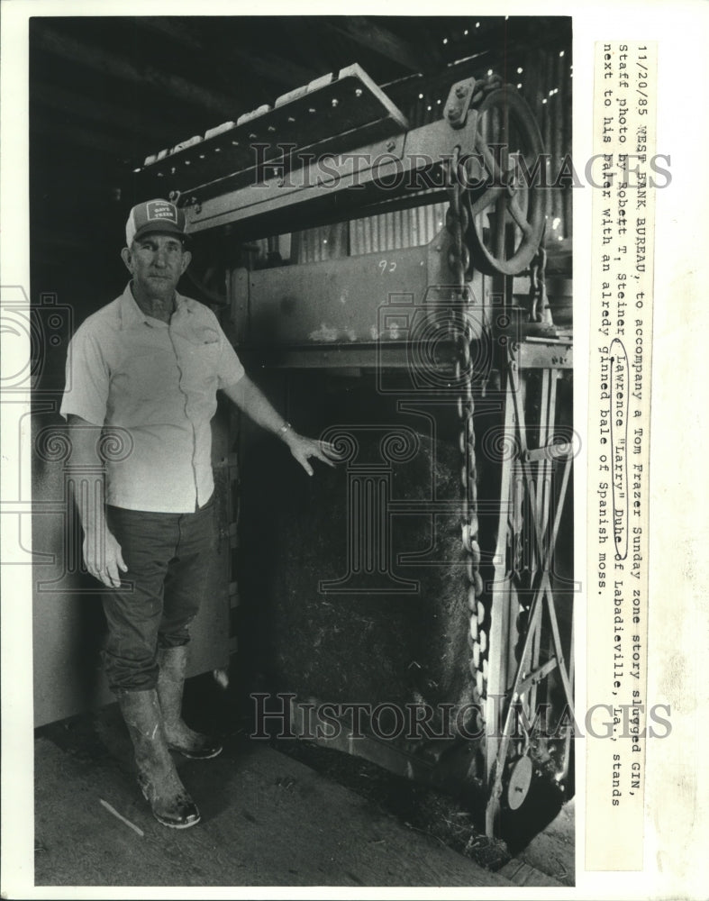 1985 Press Photo Lawrence &quot;Larry&quot; Duhe Stands Next to Spanish Moss Baler- Historic Images