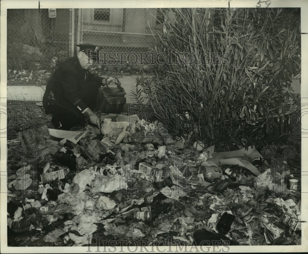 1958 Press Photo Patrolman Maurice Duvio Digs in Pile of Trash at Bienville St.- Historic Images