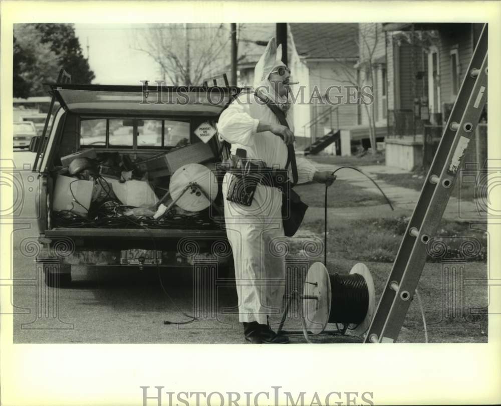 1989 Press Photo Philip Nasca dressed as Easter Bunny while installing cable- Historic Images