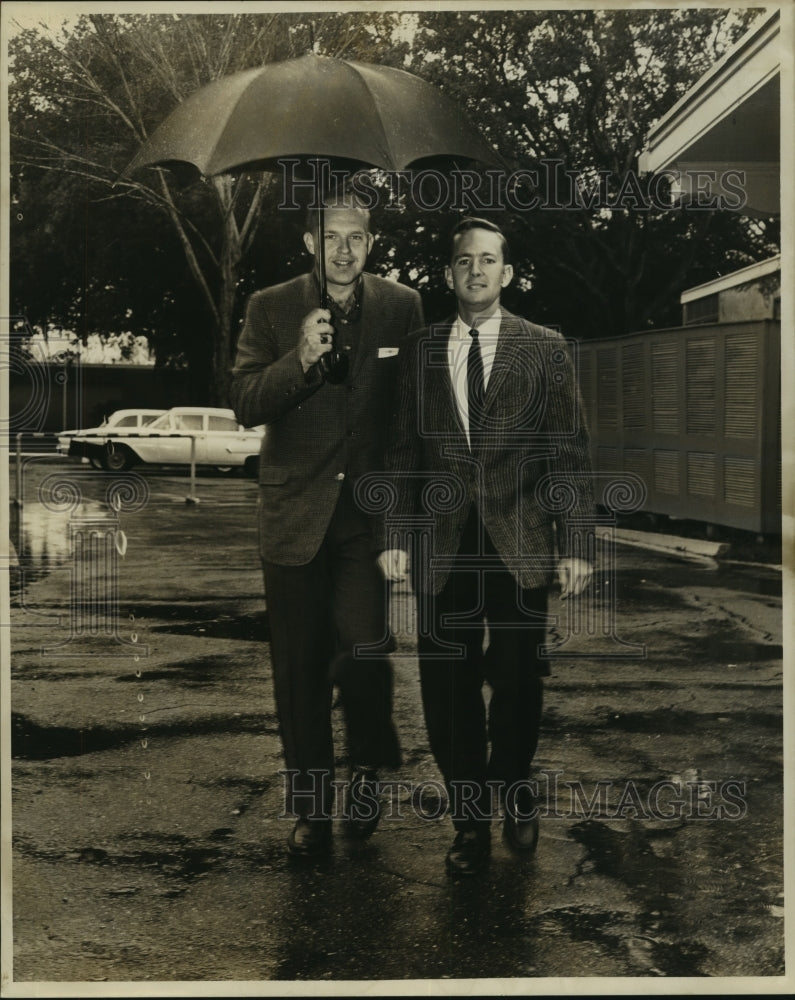  Press Photo Ron Holmbery and Lee Fentress walk in the rain.- Historic Images