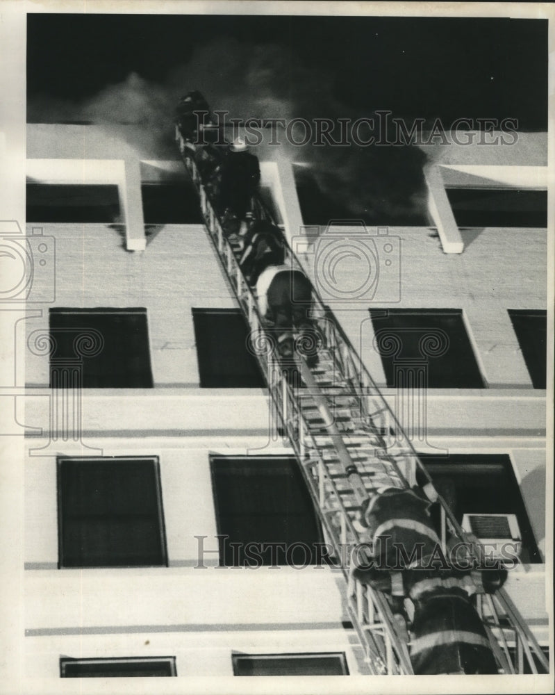  Press Photo Fireman goes up ladder to save victims of building on fire- Historic Images