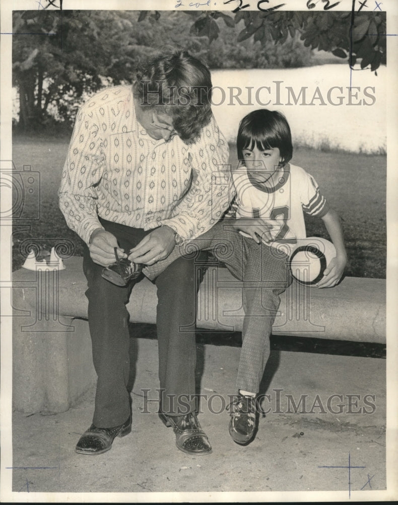 1973 Press Photo Man ties shoe for boy, Big Brothers program - Historic Images