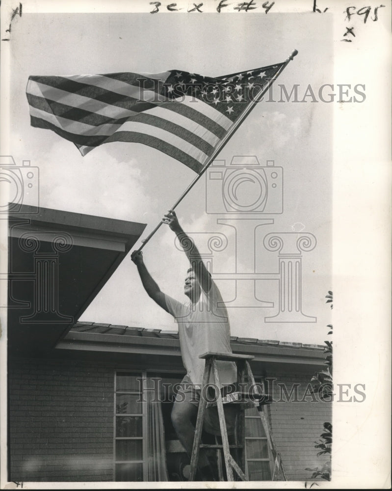 1963 Press Photo Otto Reese tacks flag to home at 1814 Mirabeau- Historic Images