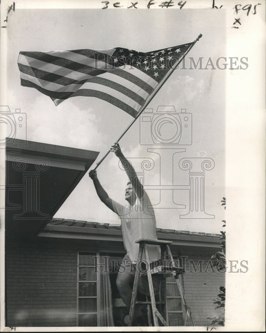 1963 Press Photo Otto Reese tacks flag to home at 1814 Mirabeau- Historic Images
