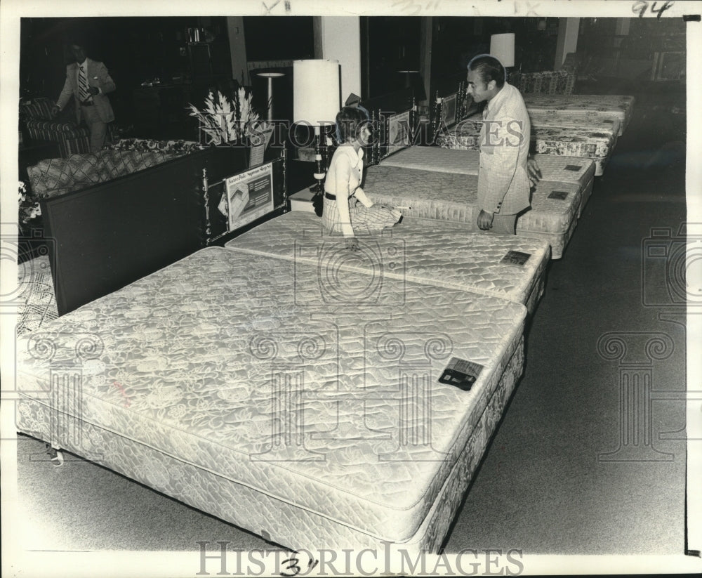 1976 Press Photo Firmin Decoa helps customer select mattress at Sears.- Historic Images