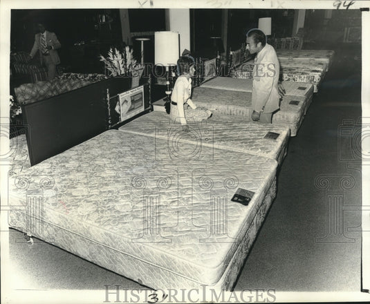 1976 Press Photo Firmin Decoa helps customer select mattress at Sears.- Historic Images