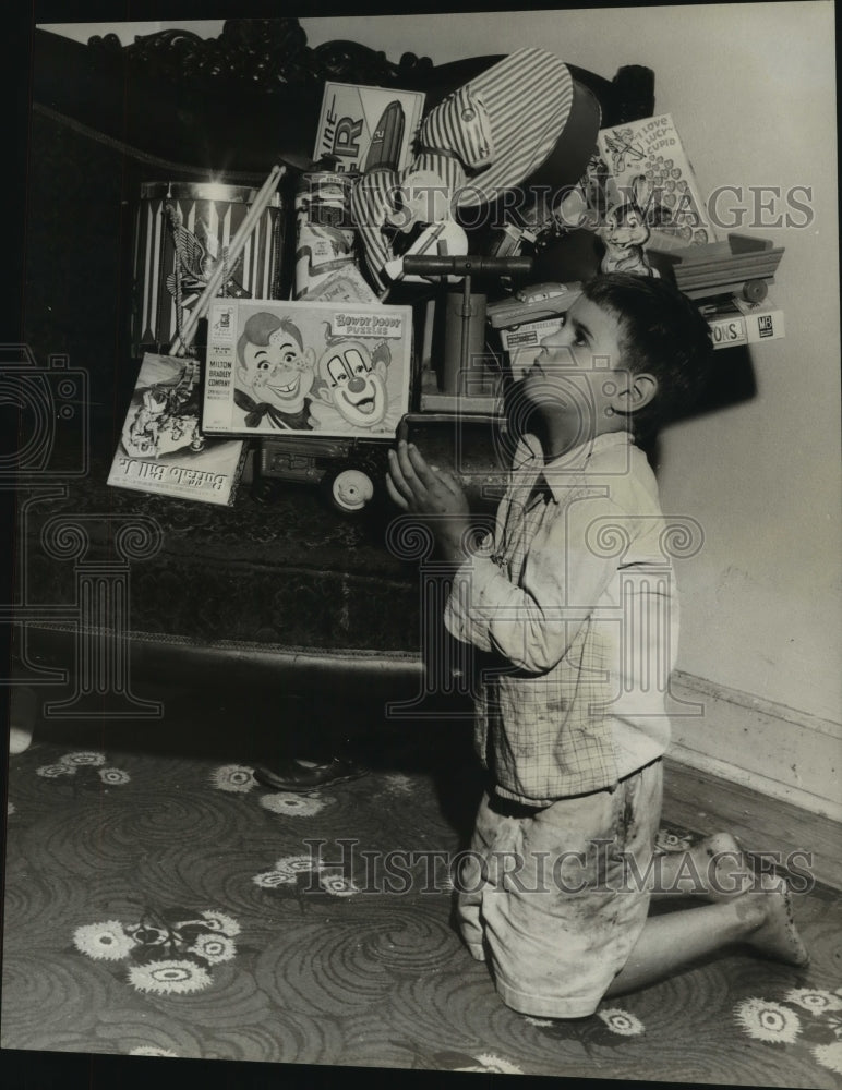 1957 Press Photo David Garcia saying his prayers among his toys - nob16477