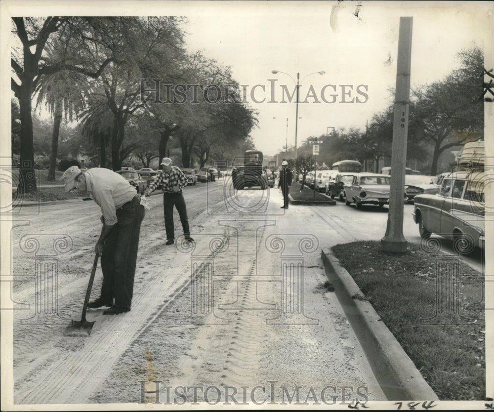 1960 Press Photo City works spread sand over spilled grease on roadway, Gentilly