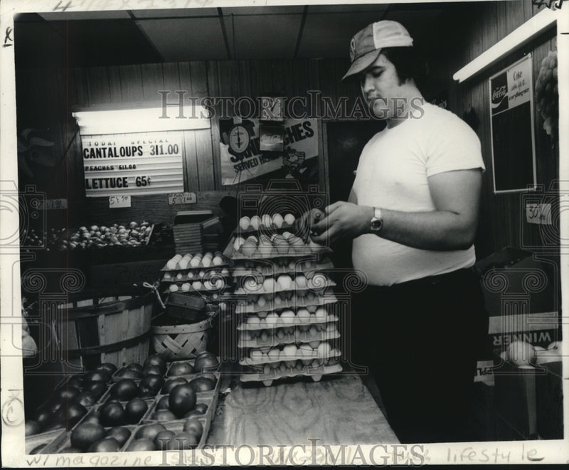 Load image into Gallery viewer, 1978 Press Photo Michael Roy of Roy's Fruit Stand sells brown eggs and produce.

