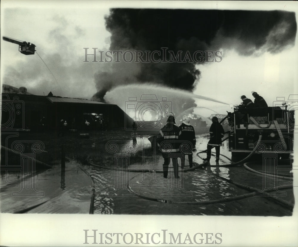 1974 Press Photo Firefighters battling fire from truck and ground.- Historic Images