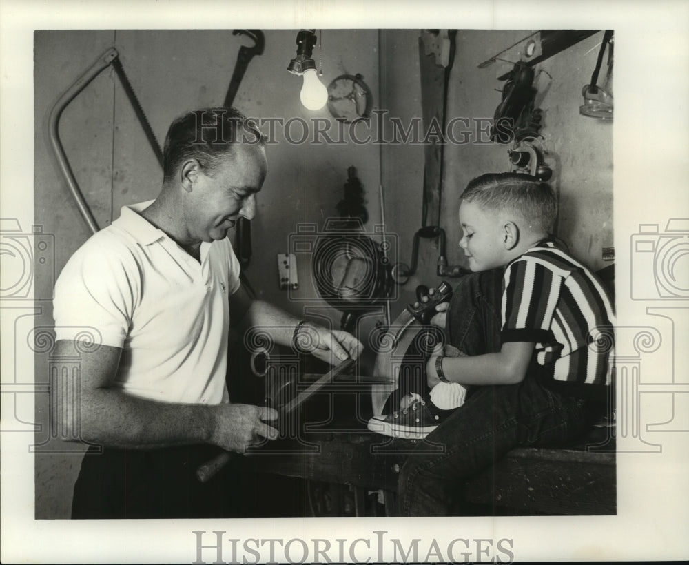 1963 Press Photo Kit Carson Hammons sharpening knife with his son - nob24004- Historic Images