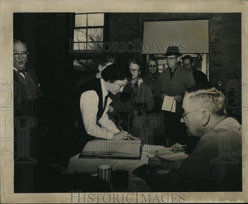 1964 Press Photo A citizen records her information to vote during an election
