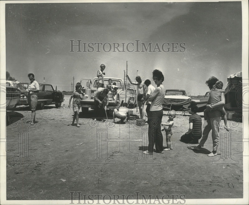 Load image into Gallery viewer, 1969 Press Photo Children watch as parents set up on the beach at Grand Isle.
