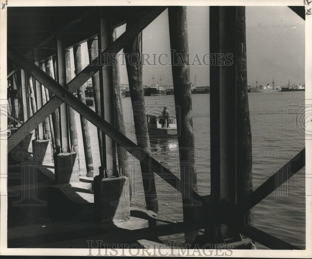 1954 Press Photo Harbor patrolman Lenny Flaspoller looks closely under the wharf- Historic Images