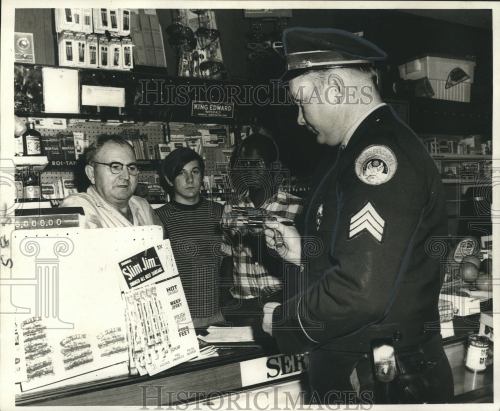 1970 Press Photo Sgt. Bernard Albers examines revolver fired by Garett Hardwick- Historic Images