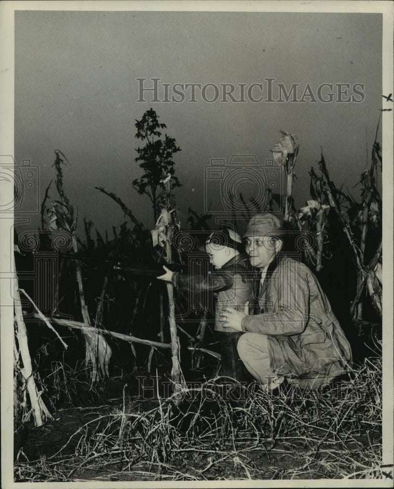 Load image into Gallery viewer, 1948 Press Photo Little Wadley Jr. takes aim as dad shoulders butt to take kick
