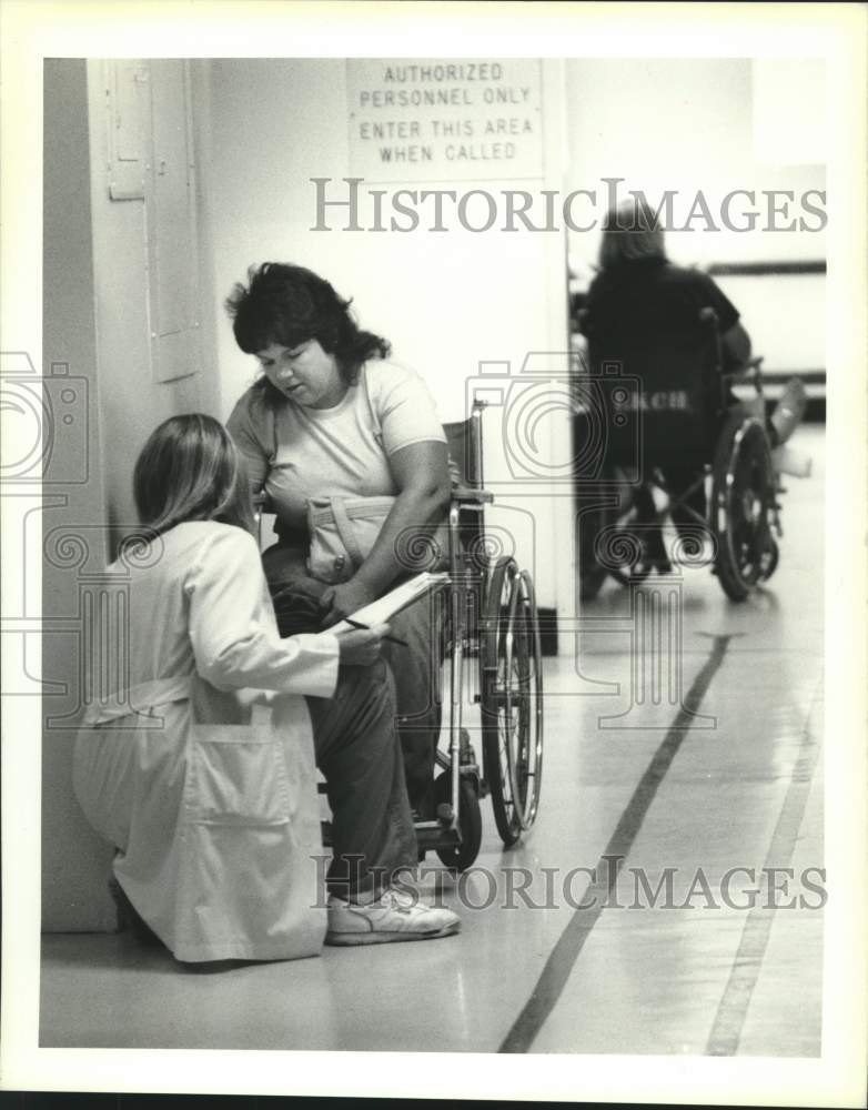 1989 Press Photo Worker at Lallie Kemp Charity Hospital with patient - nob46439