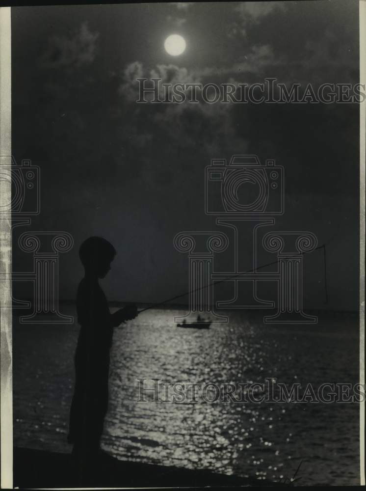 1965 Press Photo Silhouette of a youngster fishing along Lakefront Seawall- Historic Images