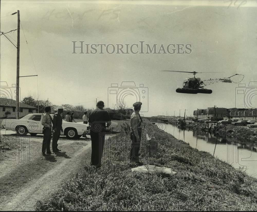 1975 Press Photo Jefferson Parish Deputies watch helicopter land-boys body found- Historic Images