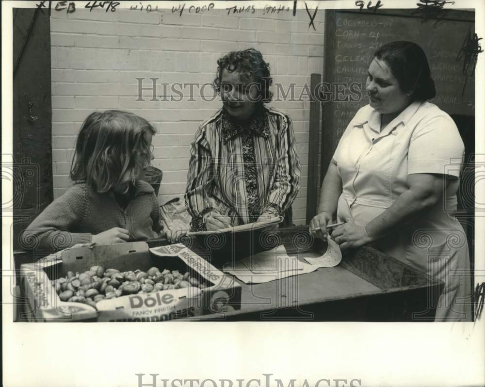 1975 Press Photo McDonogh 15 Food Co-op, Mrs. Kitiyakara & Sean discuss pricing