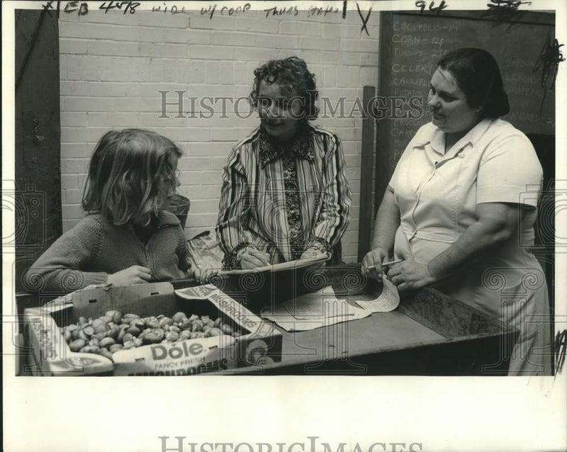 Load image into Gallery viewer, 1975 Press Photo McDonogh 15 Food Co-op, Mrs. Kitiyakara &amp; Sean discuss pricing
