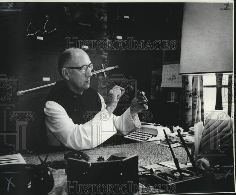 Load image into Gallery viewer, 1973 Press Photo Father Remig examines spur from unusual collection - nob59899
